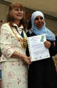 An adult learner displays her certificate
