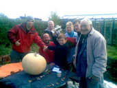 Oliver displays his prize pumpkin and trophy with his family and friends