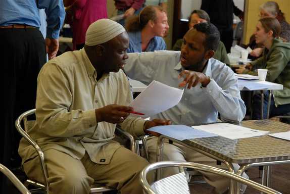 Attendees at the meeting discuss the proposals