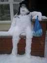 Snowman chills out on a garden wall